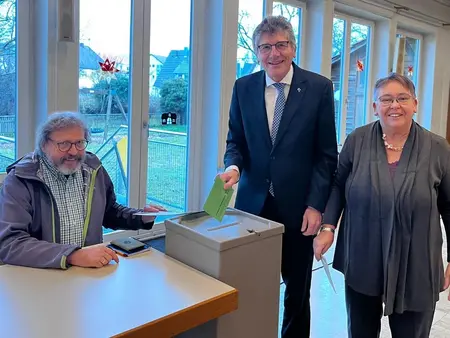 Landesbischof Ernst-Wilhelm Gohl (Mitte) bei der Stimmabgabe. Links Norbert Wacker, rechts Eleonore Härter
