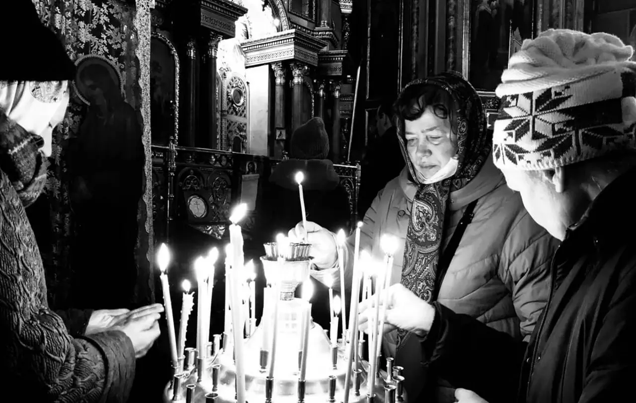 Frauen zünden in der ukrainischen Großstadt Charkiw nahe der russischen Grenze Kerzen an.