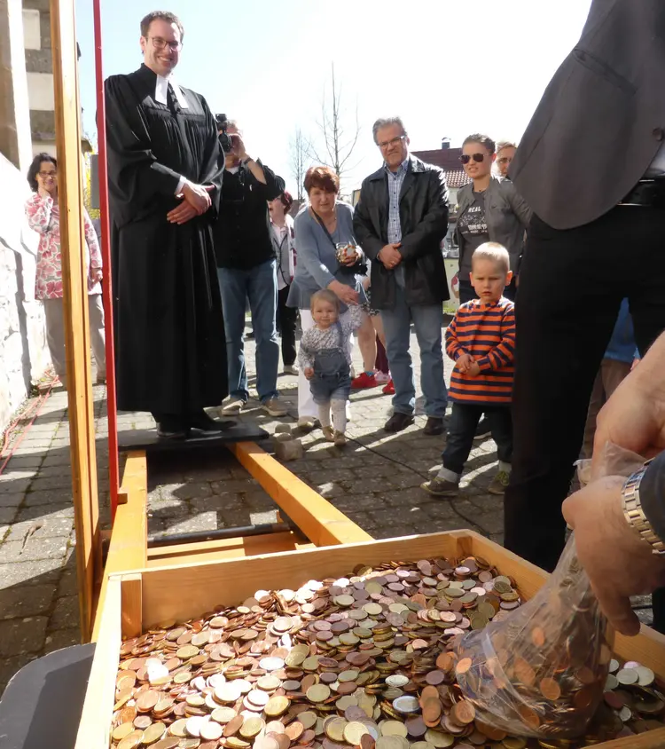 Die Kirchengemeinde Baltmannsweiler hat Pfarrer Jonathan Dörrfuß aufgewogen - mit 1.655 Euro Münzgeld und einigen „Steinen für Scheine" zugunsten der Kirchenrenovierung.