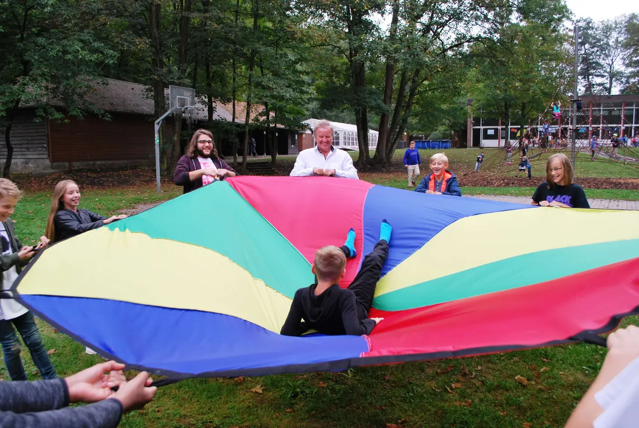 Am Ende seines Besuchs packt Franz Untersteller ein Geschenk für die Waldheimkinder aus: ein Sprungtuch.