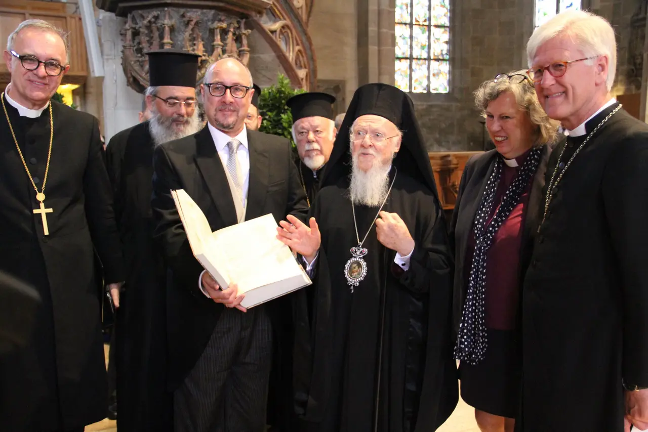 Patriarch Bartholomaios bekommt Ehrendoktorwürde verliehen Patriarch Bartholomaios überreicht Professor Dr. Michael Tilly eine Faksimile-Ausgabe des griechischen Alten Testaments; mit Landesbischof Dr. h. c. Frank Otfried July (links) und dem EKD-Ratsvorsitzenden Heinrich Bedford-Strohm (rechts).