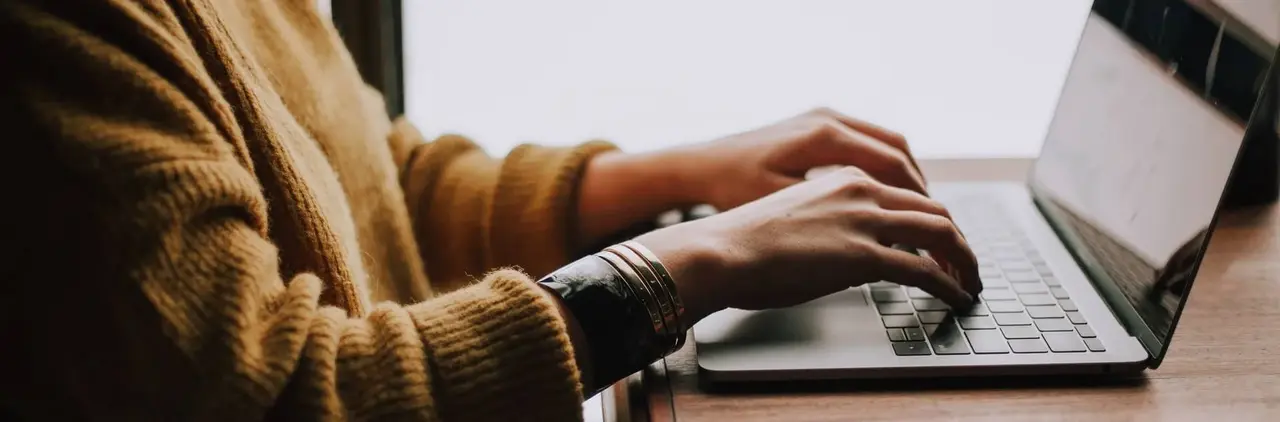 Nahaufnahme von Person, arbeitend am Laptop