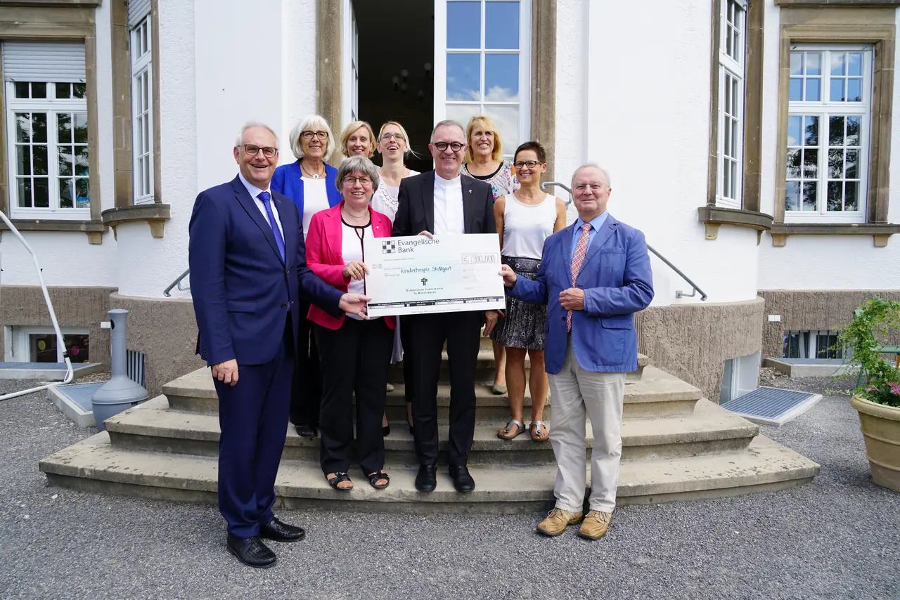 Landesbischof Dr. h. c. Frank Otfried July übergibt gemeinsame mit Synodalpräsidentin Inge Schneider einen Scheck in Höhe von 900.000 Euro.