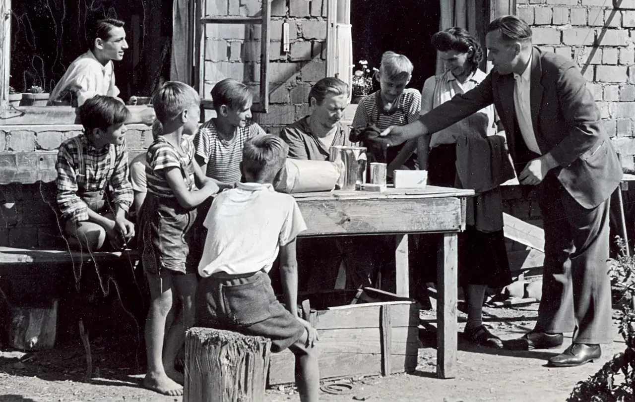 Bezirkshelfer bei einem Familienbesuch in einem Notquartier.