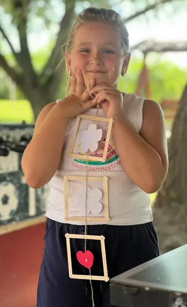 Freizeitteilnehmerin mit selbst gebasteltem Geschenk Eine junge Freizeitteilnehmerin freut sich über ihr selbst gefertigtes Geschenk.