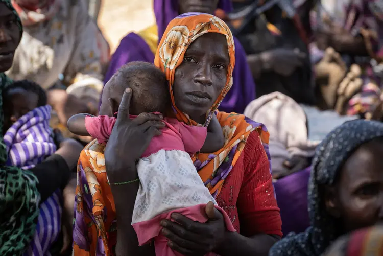 Eine Mutter hält ihre kleine Tochter inmitten einer Gruppe von Flüchtlingsfrauen, die nach ihrer Flucht vor den schweren Gewalttaten im Zusammenhang mit dem Bürgerkrieg im Sudan im Tschad Zuflucht gesucht haben, in Doroti im Osten des Tschad.