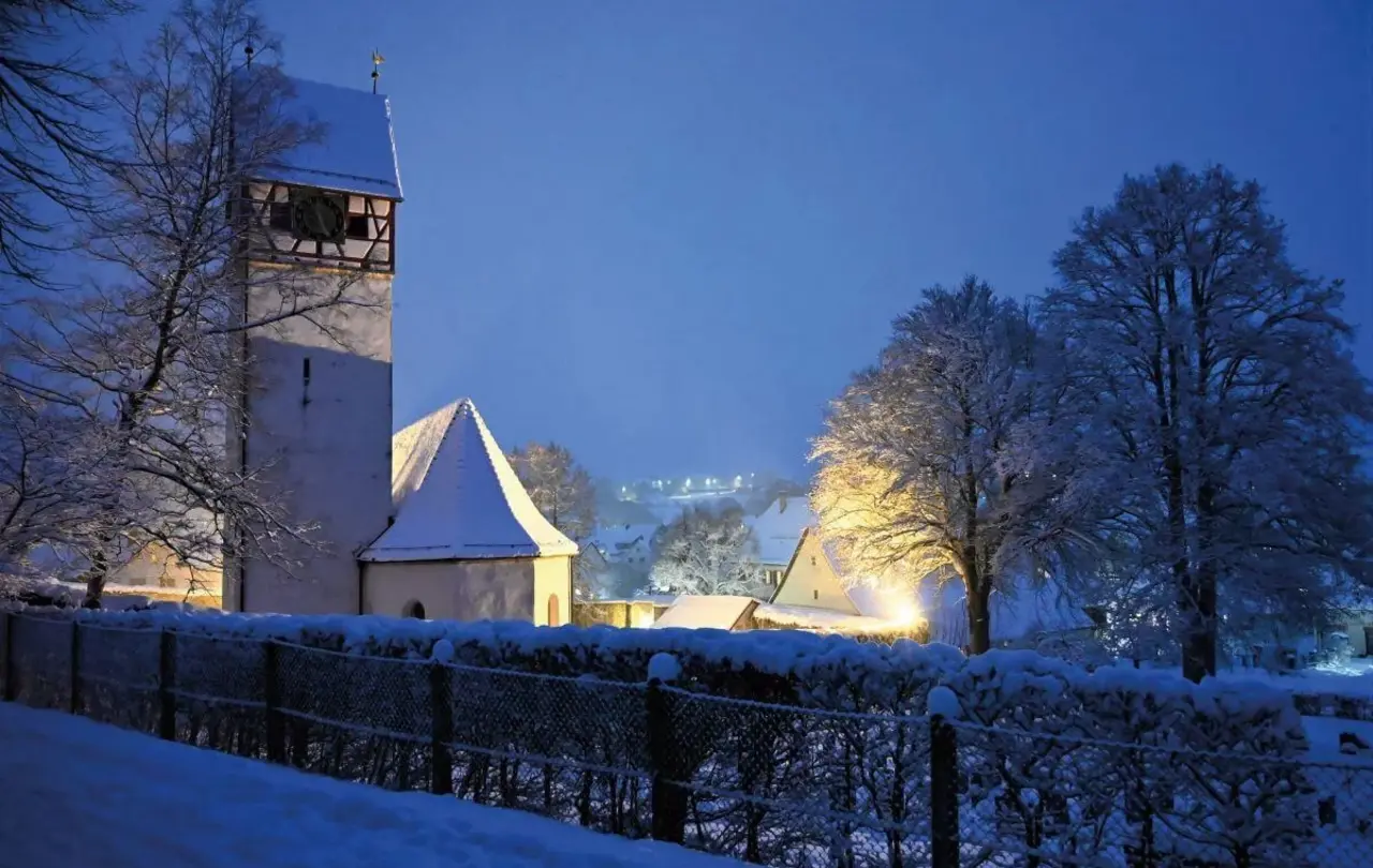 Die verschneite Martinskirche in Zainingen am Abend.