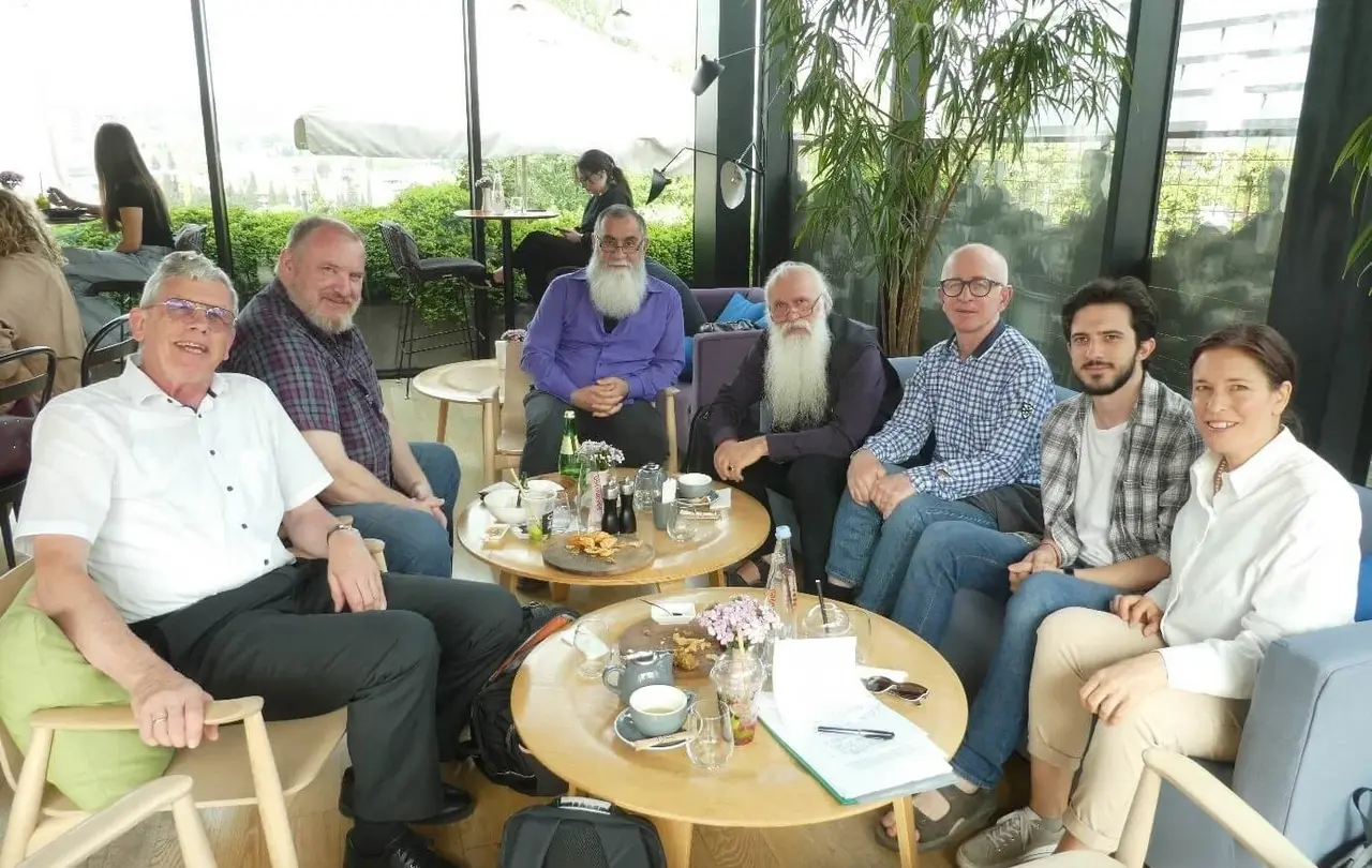 Besprechung zur Übersetzung der Erklärungsbibel 2023 ins Georgische. Von links nach rechts: Ulrich Heckel, Rolf Bareis, Bishop Ilia Osepashvili (Ev. Baptist Church of Georgia), Metropolitan Bishop Prof. Dr. Malkhaz Songulashvili (Evangelical Baptist Church of Georgia, Ilia State University, Georgische Bibelgesellschaft), Abtandil Guruli  (Georgische Bibelgesellschaft), Stud. Theol. Mate Saralishvili (Ev. Baptist Church of Georgia), Susanne Schenk. Im Vordergrund die Skizze des Memorandum of Agreement über den Start des Projekts, das später von allen unterzeichnet wurde. Osepashvili und Saralishvili werden die ersten Texte übersetzen. Kooperationspartner sind: die Georgische Bibelgesellschaft, die Ilia State University, die Evangelisch-Lutherische Kirche in Georgien und dem Südlichen Kaukasus und die Evangelical Baptist Church of Georgia.
