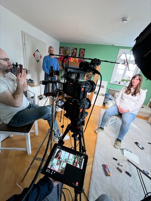 Pfarrerin Sara Stäbler im Wohnzimmer-Filmset, zusammen mit drei Männern an der Kamera