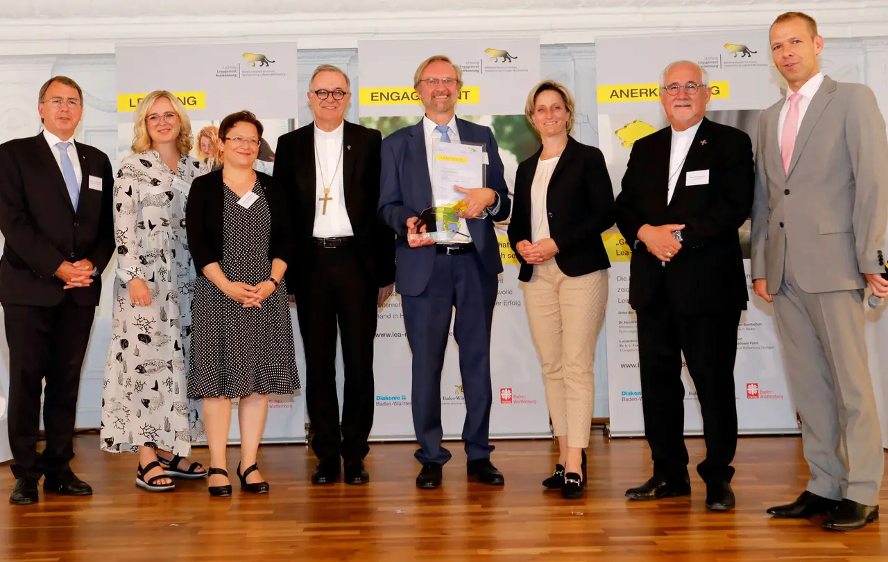 Preisträger 2019 in der Kategorie der Unternehmen mit bis zu 500 Mitarbeitern: Für die Bäckerhaus Veit GmbH aus Bempflingen nahm Johannes Klümpers die Auszeichnung entgegen. Links neben ihm (v.l.n.r.) Oberkirchenrat Dieter Kaufmann (Vorstandsvorsitzender des Diakonischen Werks Württemberg, Bettina Schmauder (Bund der Selbstständigen Baden-Württemberg e. V.), Dr. Anette Holuscha-Uhlenbrock (Vorstand des Caritasverbandes der Diözese Rottenburg-Stuttgart) und Landesbischof Dr. h. c. Frank Otfried July. Rechts neben ihm Wirtschaftsministerin Dr. Nicole Hoffmeister-Kraut, Bischof Dr. Gebhard Fürst und Moderator Helge Thun.