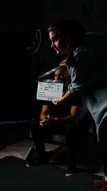 Frau mit Filmklappe bei Videodreh mit Flavio Simonetti