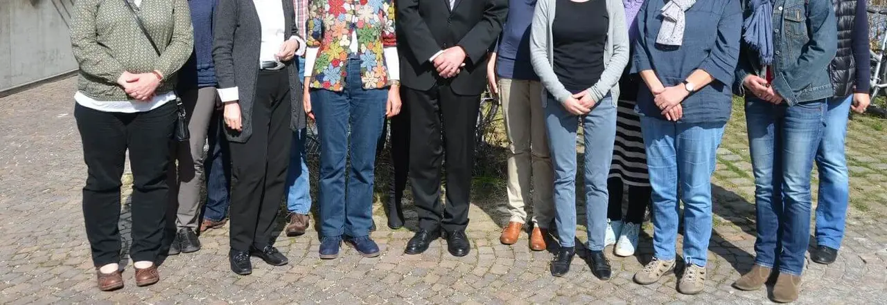 Oberkirchenrat Dieter Kaufmann (Mitte) und die Abteilung Migration begrüßen neue Mitarbeitende in der Flüchtlingsarbeit.