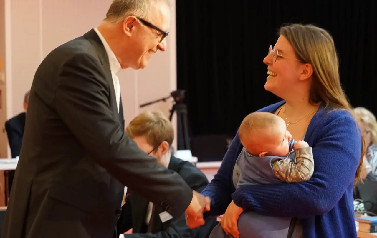 Jasmin Blocher (LG) legt per Handschlag mit Landesbischof Dr. h. c. Frank Otfried July ihr Gelübde ab. Sohn Noah ist Zeuge.