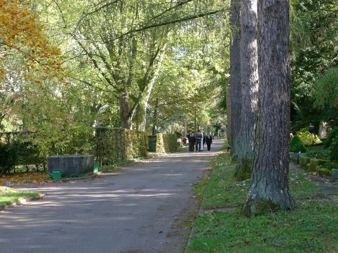 Die kleine Trauergemeinde macht sich auf den Weg zur letzten Ruhestätte.