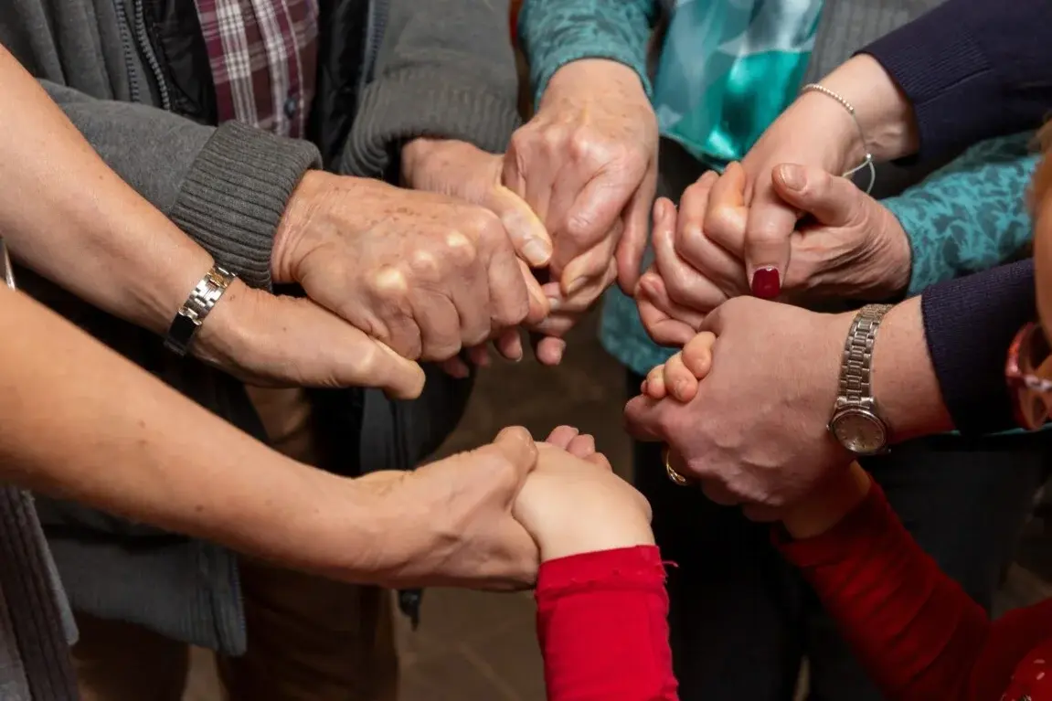 Gruppe Betender, die sich an den H#nden halten.