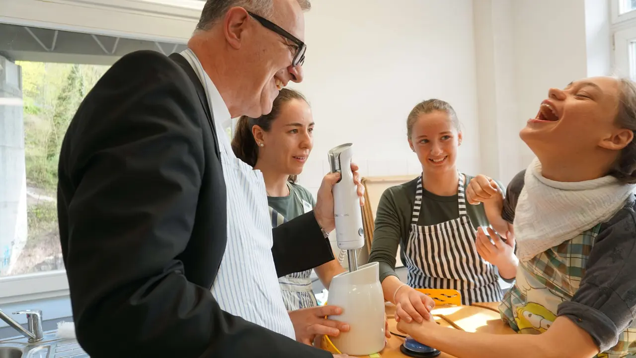 Landesbischof July kocht zusammen mit Schülerinnen und Schülern in der Torwiesenschule in Stuttgart.