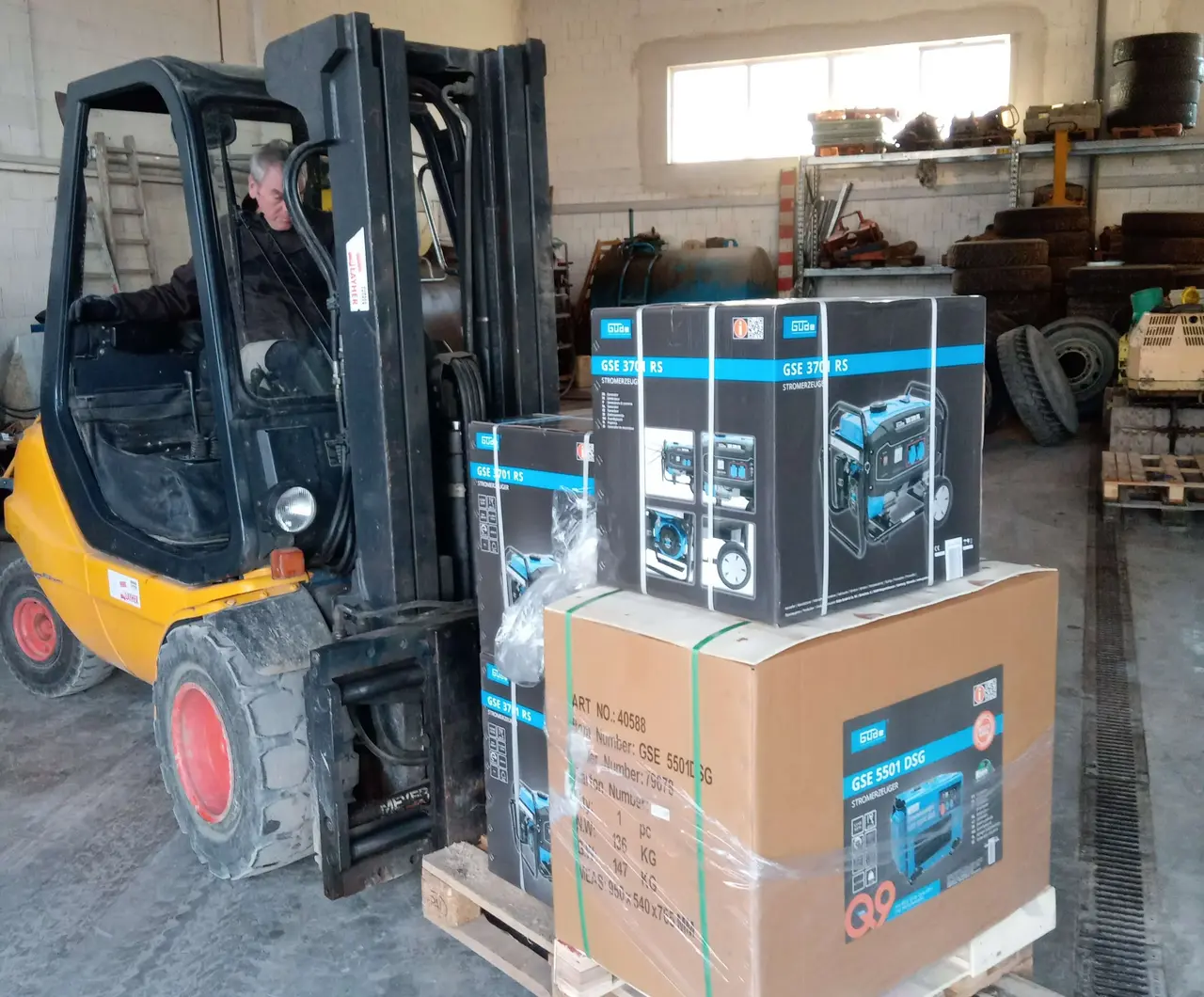 Geräte zur Stromerzeugung werden mit einem Gabelstapler transportiert und aufgeladen.